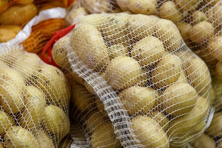 potatoes in the mesh bags at farmers marketの写真素材