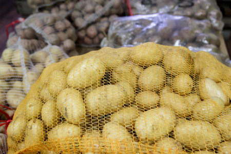 potatoes in the mesh bags at farmers marketの写真素材