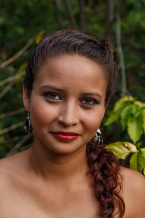 atractive latin woman showing handmade earrings in natureの写真素材
