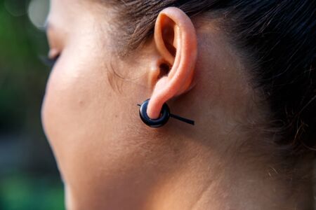 woman wearing a handmade earringの写真素材