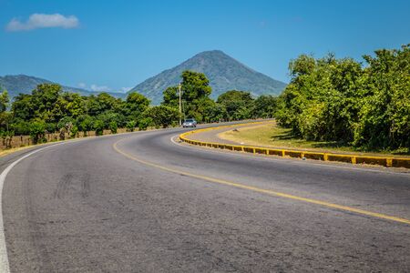 curve road view with volcano at background in blue sky from Nicaraguaの写真素材