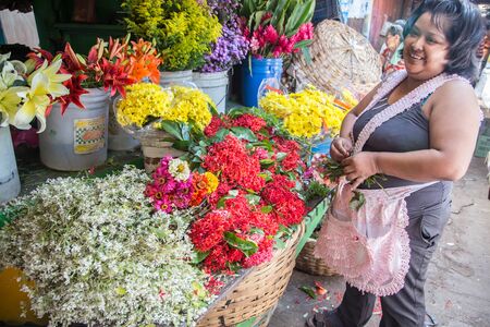 Granada, Nicaragua - December 22, 2015: Market daily life view. woman buying flowersのeditorial素材