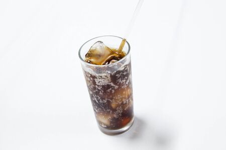 black soda on glass with ice isolated on whiteの写真素材