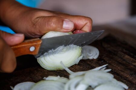 cutting onion with knifeの写真素材