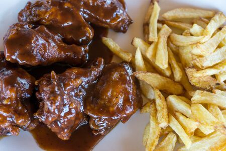 plate of chicken wings with french friesの写真素材