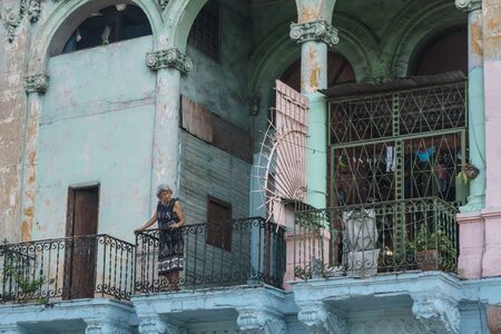 La Havana, Cuba â December 25, 2016: old woman on an old balcony from houseのeditorial素材