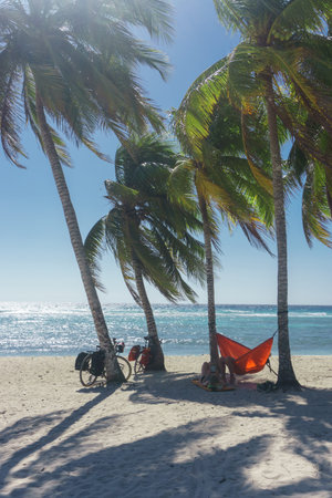 playa giron, Cuba â€“ January 2, 2017:  Travelers relaxing on hammocks with bikes on tropical...