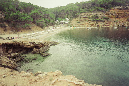 Benirras beach, Ibiza, Spain - 27 August, 2017: incredible turquoise waters on Ibiza's magnificent beach, with tourists at the bottom of the image enjoyingのeditorial素材
