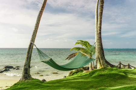 relaxing concept, beautiful tropical beach with hammock on palmsの写真素材