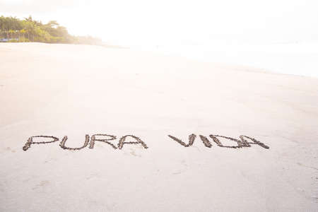 Handmade inscription on the sand of a beach with the phrase pure life. Costa Ricaの写真素材