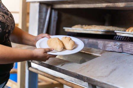 Woman taking two pieces of bread from a ovenの写真素材