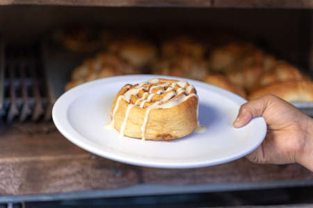 sweet pastry covered with cream in a dish in front of an industrial ovenの写真素材