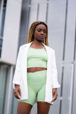 Portrait of a young black woman in sportswear in front of a modern buildingの写真素材