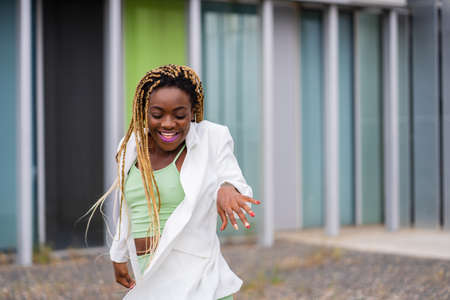 Photo with copy space of a afro woman with braids dancing energically outdoorsの写真素材