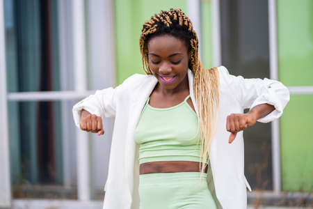 Sportive beauty african woman dancing while smile outdoorsの写真素材