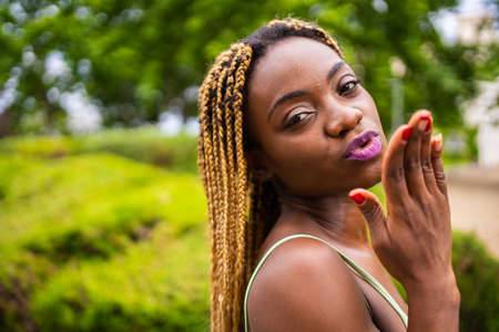 Young african woman gesturing a kiss to the camera on a gardenの写真素材