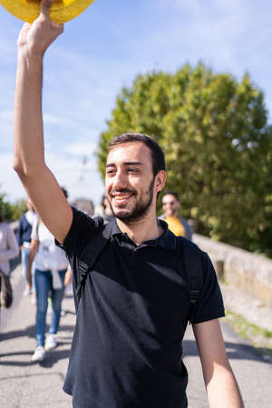 Tour guide raising a hat in front of the group of tourists on a medieval castleの写真素材