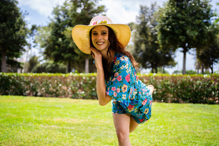 Beauty woman posing while dancing in summer clothes in a gardenの写真素材