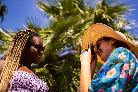 Young African woman posing for a woman taking pictures of herの写真素材