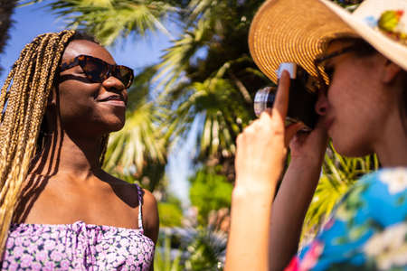 Focus on the face of an african woman posing for a woman taking pictures of herの写真素材