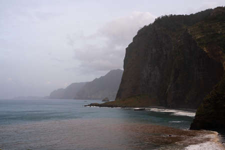 Cliffs and rock formations facing the sea in cloudy weatherの写真素材