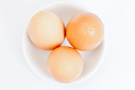 Three Eggs in a Little White Saucer with the Isolated Background