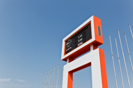 The electric scoreboard and the flagstaff with the blue sky backgroundの写真素材