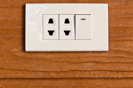 The closeup image of the old sockets and switch on the wooden wall