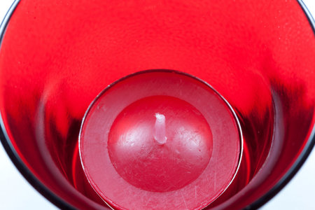 The closeup image of the red circular candle in the red glassの写真素材