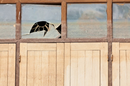 The closeup image of the broken glass window and wooden windows