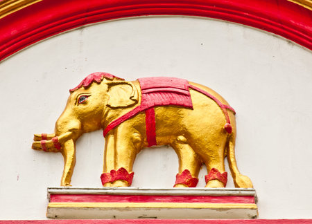 The closeup image of the bas relief sculpture of golden elephant in a temple of Thailand