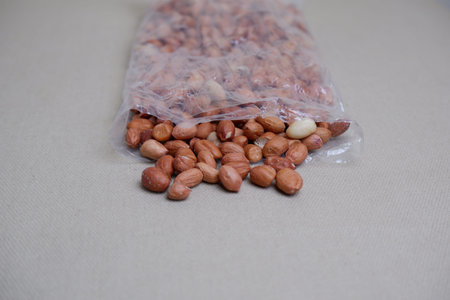 Peanuts in a plastic bag on a gray background. Selective focus.