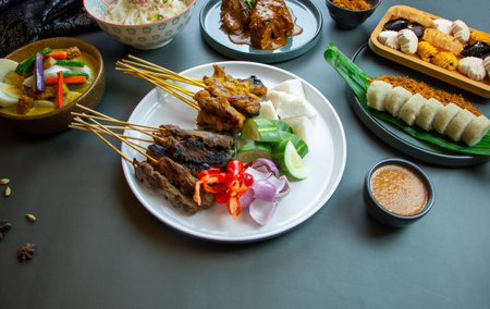 Chicken or beef satay served on white plate with condiments such as cucumber, onion, compressed rice (nasi impit). Popular  festive food Singapore, Malaysia & Indonesia.の写真素材