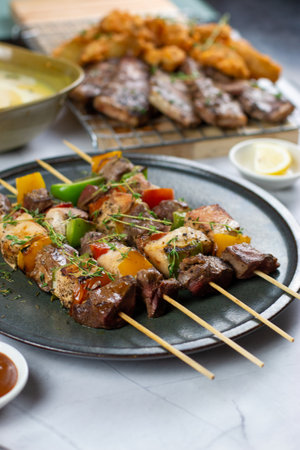 Grilled meat on skewers with vegetables on a plate. Good for any festive or family gathering.の写真素材