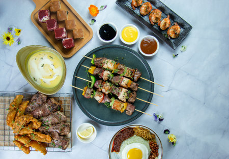 Grilled meat on skewers, nasi lemak with fried egg, grilled prawns, marinated lamb cutlets, pumpkin soup & pieces cake as desserts.の写真素材