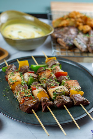 Skewers of meat with vegetables on skewers on a plate. Good for any festive or family gathering.の写真素材
