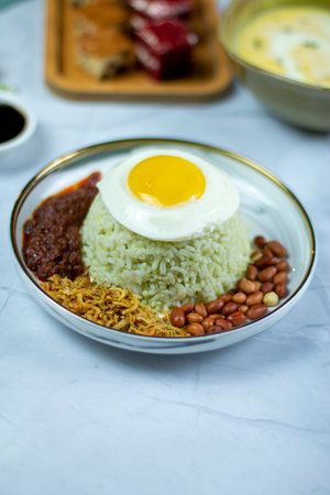 Nasi lemak or coconut milk rice served with spicy sambal, fried egg and condiments.の写真素材