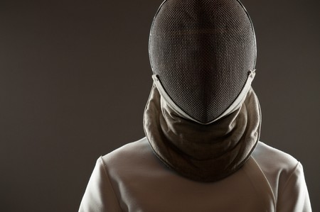 Studio portrait of fencing athlete wearing face protective mask, copy spaceの写真素材