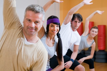 Happy smiling people doing aerobic exercises together at gymの写真素材
