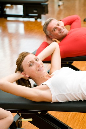 Young lady making sit-ups on bench at gymの写真素材