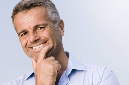 Satisfied mature businessman smiling and looking at cameraの写真素材