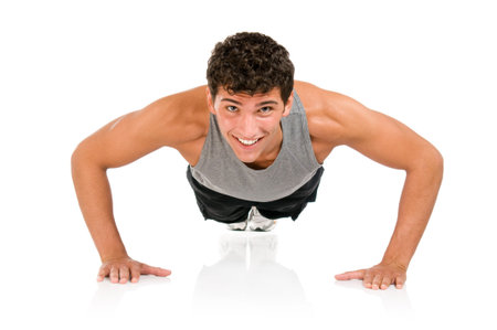 Young smiling fitness man doing push ups on floor, studio shot isolated on white background