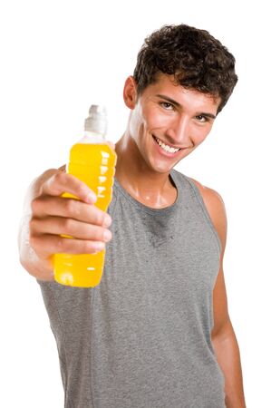 Happy young sweated man showing a bottle of energy drink after fitness training isolated on white backgroundの写真素材