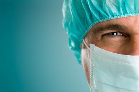 Mature male surgeon gazing and looking at camera at hospital, close up shotの写真素材