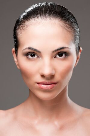 Beautiful young brunette woman looking at camera, beauty studio portraitの写真素材