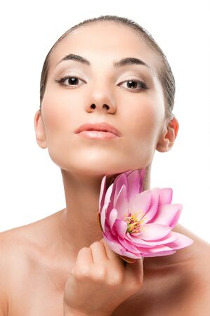 Beautiful young lady with lotus flower looking at camera isolated on white background, professional beauty makeupの写真素材
