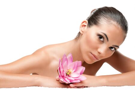 Beautiful young woman lying on white towel during a spa treatment isolated on white background, professional beauty makeupの写真素材
