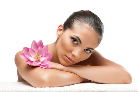 Young beautiful woman relaxing with lotus flower at spa isolated on white background, professional beauty makeupの写真素材