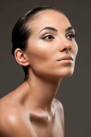 Beautiful female model with professional fashion makeup posing over gray backgroundの写真素材