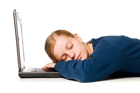 Detail of a cute blonde girl sleeping on her laptop computer, isolated on white backgroundの写真素材